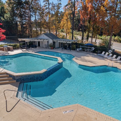 The pool at the park at Sugar Mill apartments with sun chairs and multi level pool. 